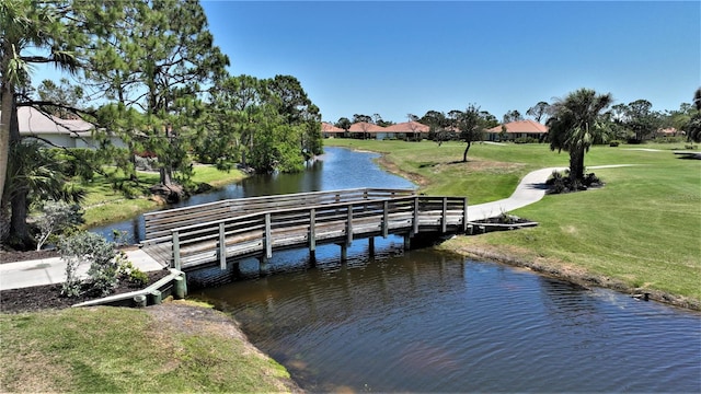 dock area with a water view and a lawn