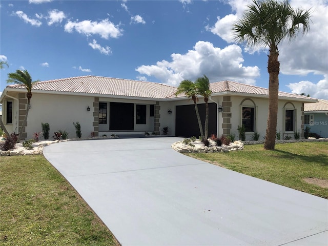 mediterranean / spanish home featuring a front lawn and a garage