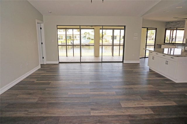 unfurnished living room with vaulted ceiling and dark hardwood / wood-style floors