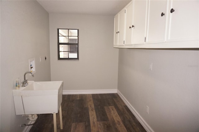 laundry area with dark hardwood / wood-style floors, cabinets, electric dryer hookup, and sink