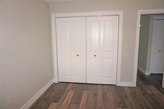 unfurnished bedroom with a closet and dark hardwood / wood-style floors