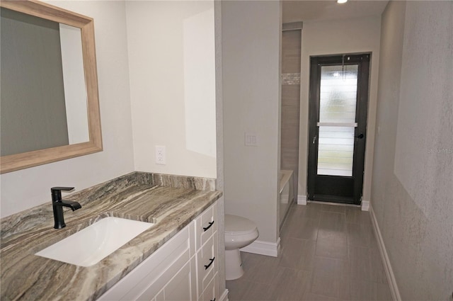 bathroom with toilet, tile flooring, plenty of natural light, and vanity