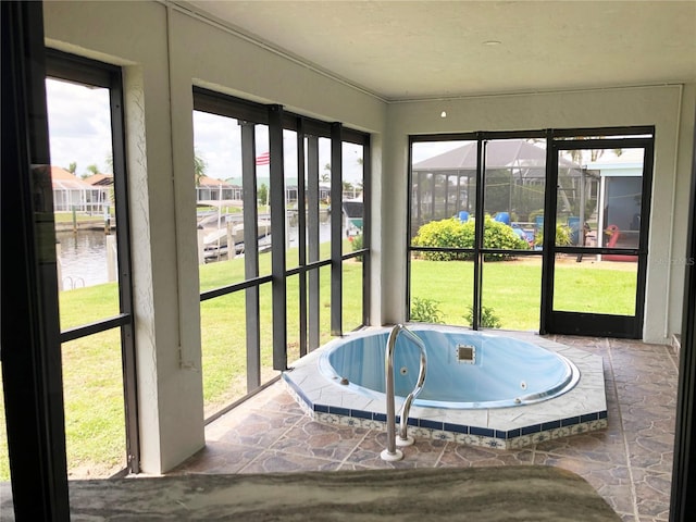 sunroom featuring a water view and a healthy amount of sunlight