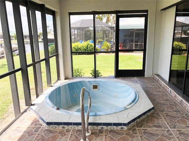 sunroom featuring a wealth of natural light and a hot tub