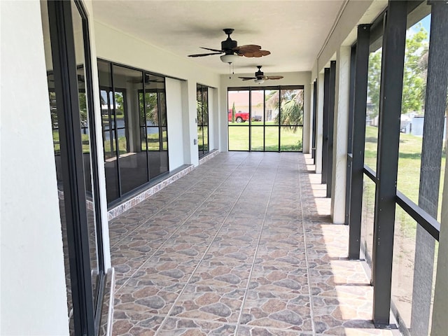 unfurnished sunroom with ceiling fan