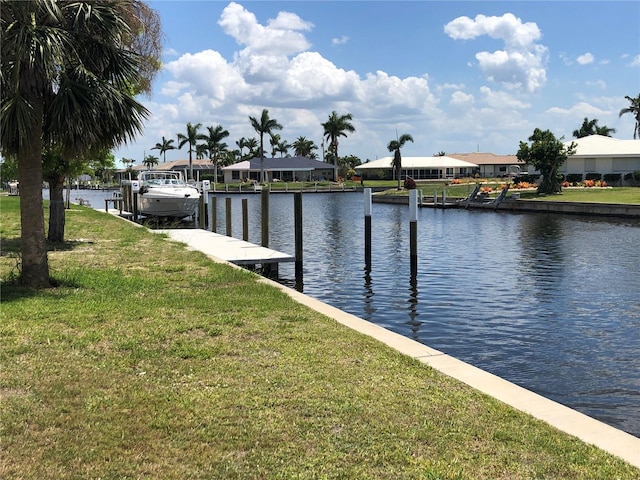 view of dock featuring a water view and a yard