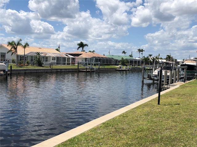 view of dock with a water view, a lanai, and a yard