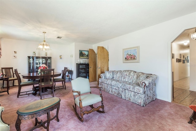 tiled living room featuring an inviting chandelier