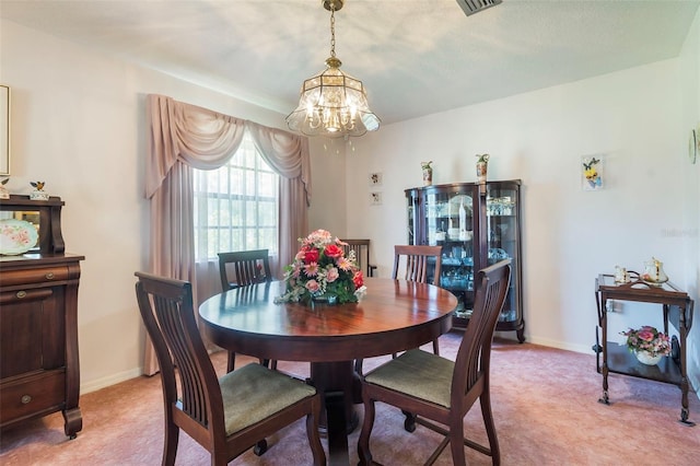 carpeted dining space featuring a chandelier