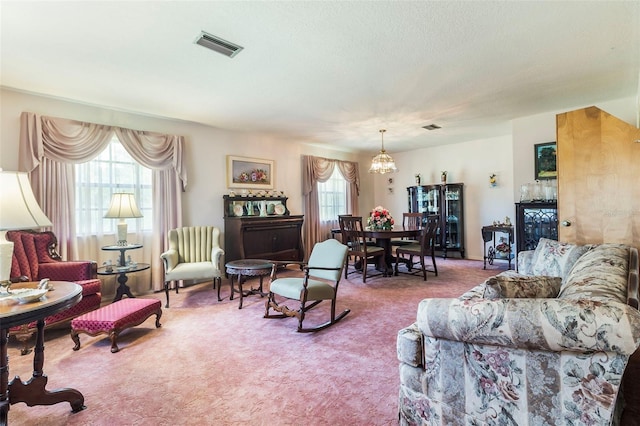 carpeted living room with a notable chandelier and plenty of natural light