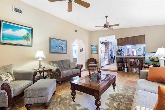 tiled living room with ceiling fan and vaulted ceiling