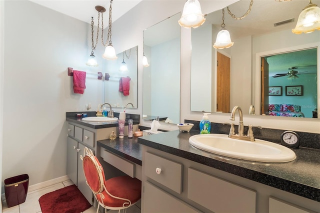 bathroom with dual sinks, tile floors, ceiling fan, and vanity with extensive cabinet space