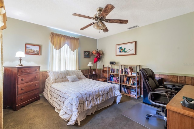 carpeted bedroom with ceiling fan and a textured ceiling