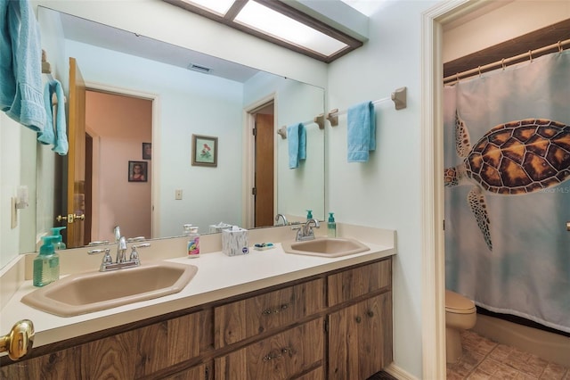 bathroom featuring tile floors, toilet, and dual vanity