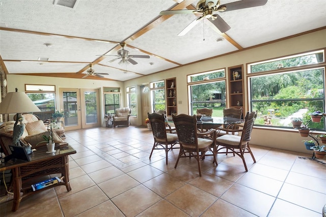 tiled dining room with a textured ceiling, vaulted ceiling, ceiling fan, and french doors