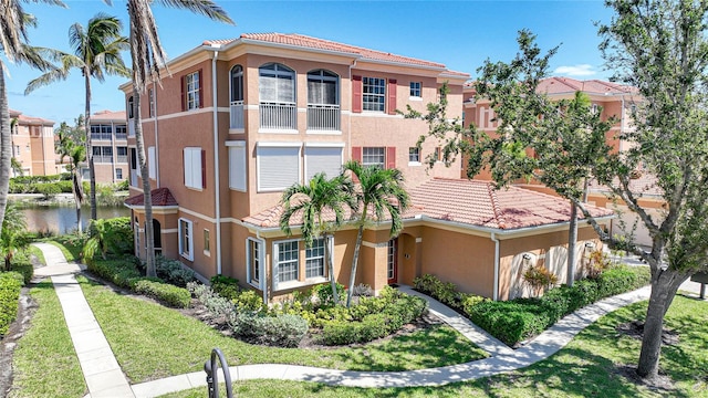 view of front of property featuring a balcony and a front yard