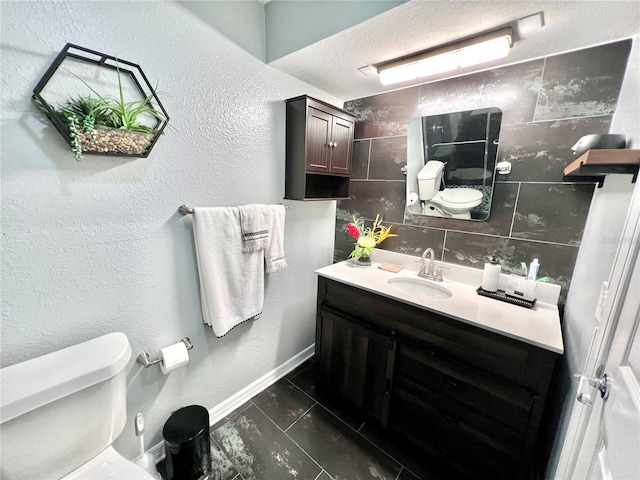 bathroom with toilet, a textured ceiling, vanity, and tile flooring