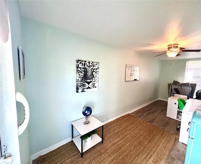 living room with ceiling fan and dark wood-type flooring