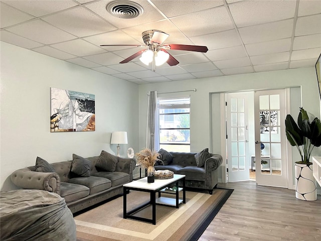 living room with hardwood / wood-style flooring, french doors, ceiling fan, and a drop ceiling