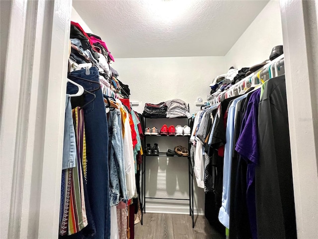 walk in closet with dark wood-type flooring