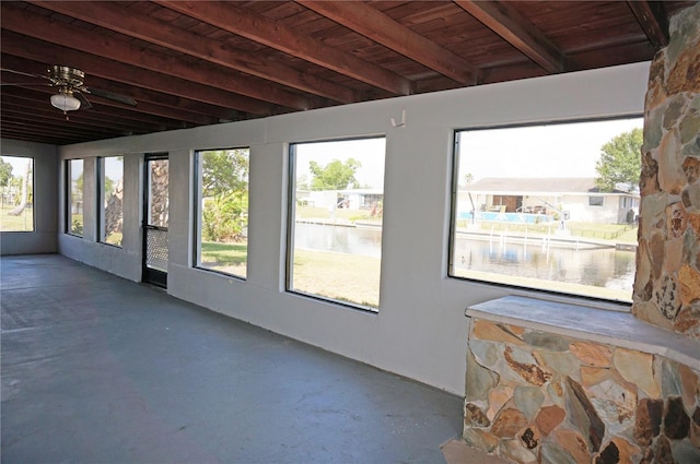 unfurnished sunroom featuring a wealth of natural light, wooden ceiling, and a water view