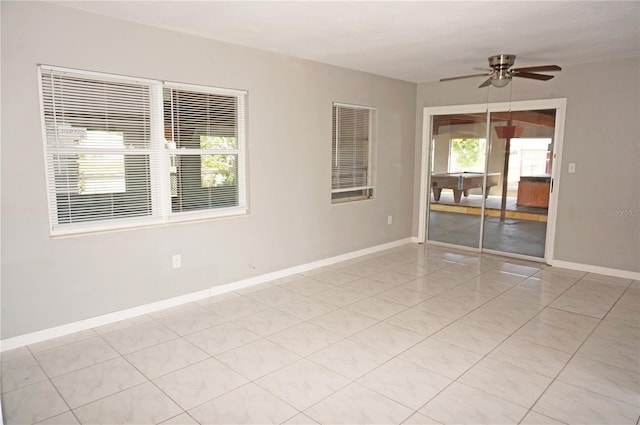 tiled spare room featuring plenty of natural light and ceiling fan