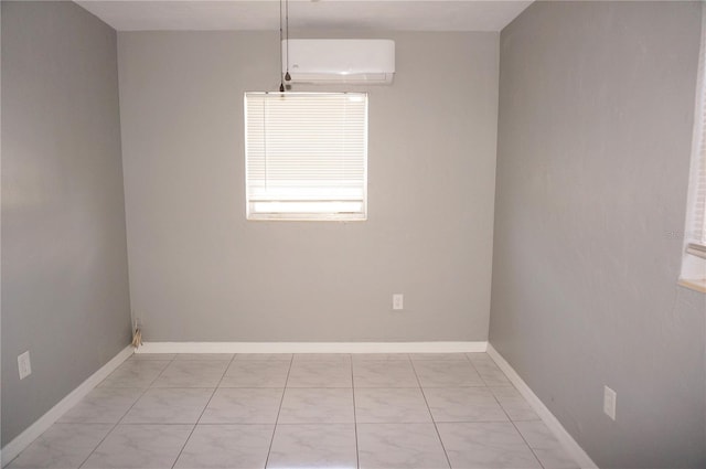 spare room featuring a wall unit AC and light tile floors