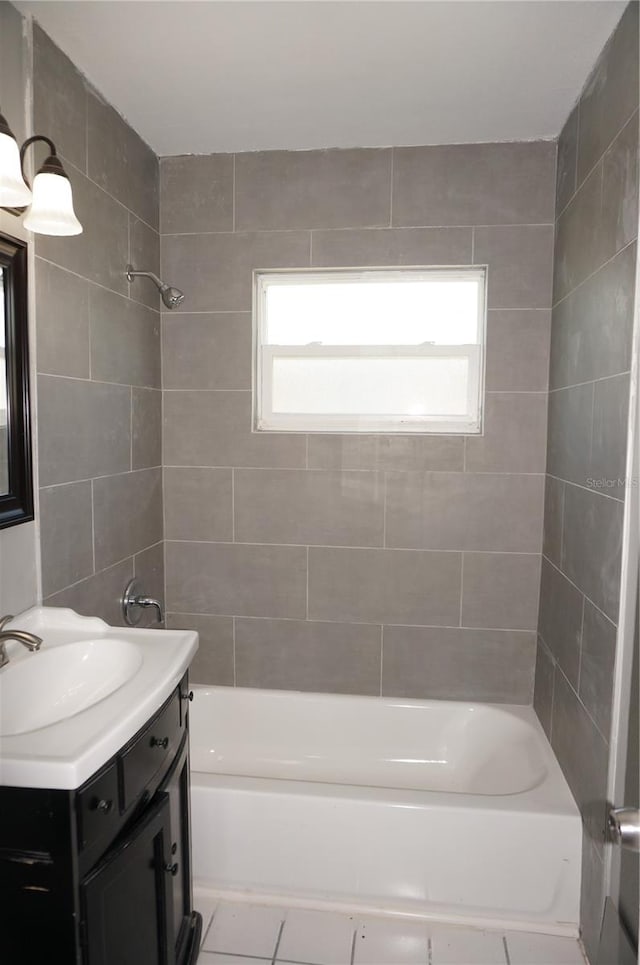 bathroom with plenty of natural light, tiled shower / bath combo, vanity, and tile flooring