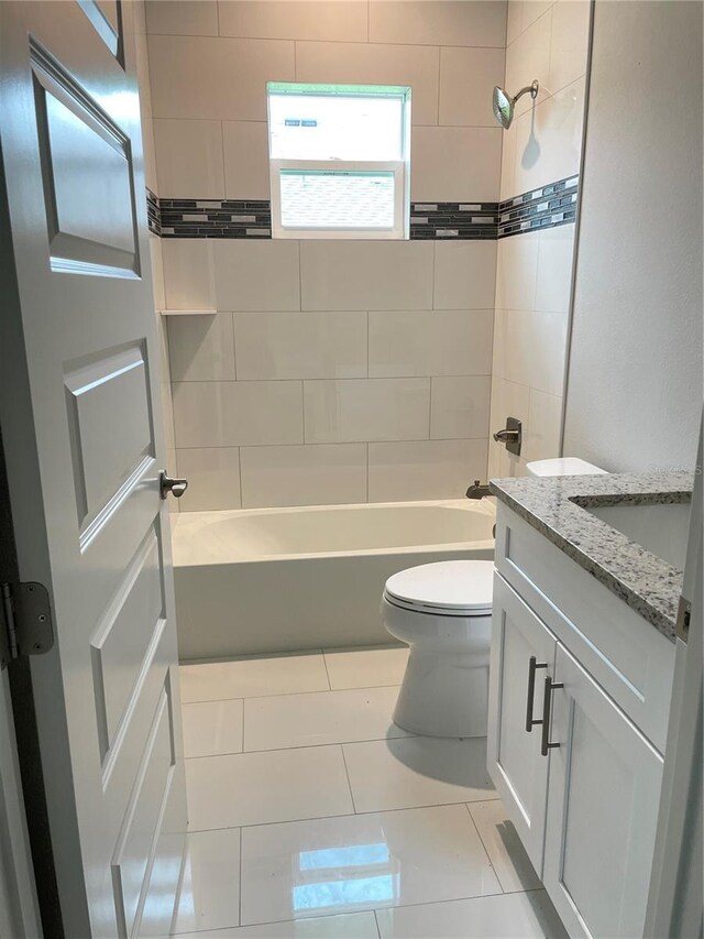 full bathroom with tile patterned flooring, tiled shower / bath, toilet, and vanity