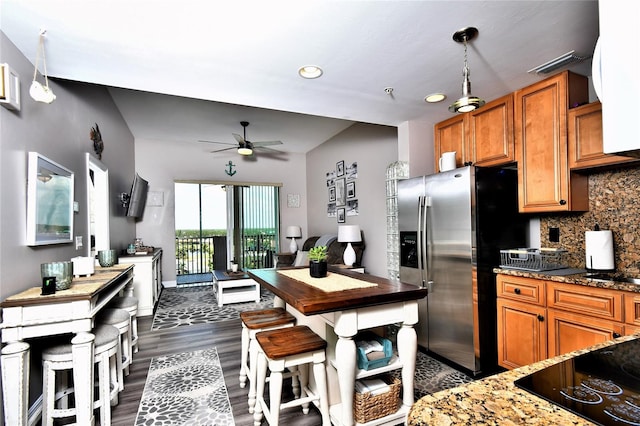 kitchen with hanging light fixtures, dark wood-type flooring, ceiling fan, black electric stovetop, and tasteful backsplash