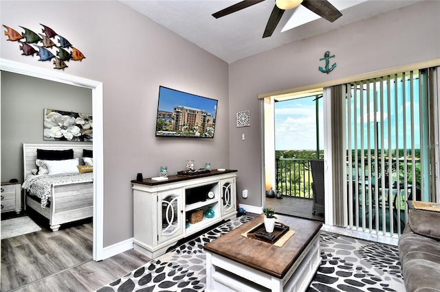 living room featuring wood-type flooring, ceiling fan, and lofted ceiling