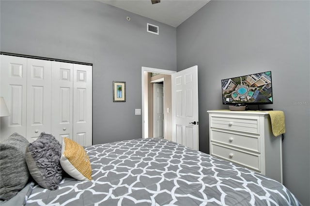 bedroom with high vaulted ceiling and a closet