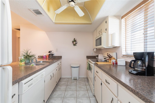 kitchen with light tile patterned floors, white cabinetry, sink, and white appliances