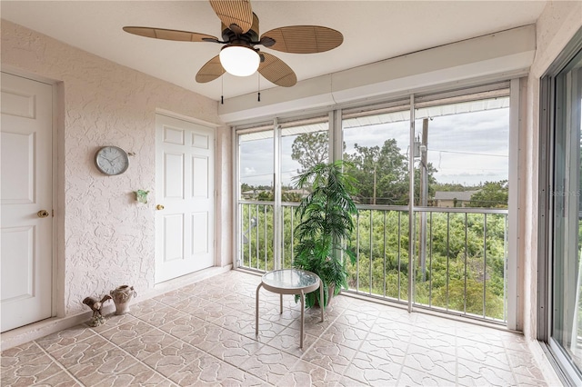 unfurnished sunroom featuring ceiling fan and plenty of natural light