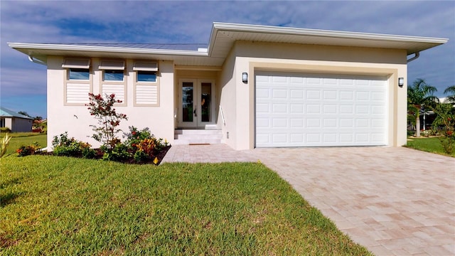 view of front of home featuring french doors, a front yard, and a garage