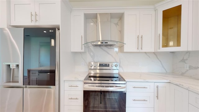 kitchen with appliances with stainless steel finishes, tasteful backsplash, white cabinetry, and wall chimney exhaust hood