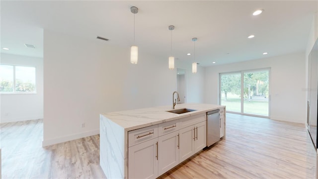 kitchen featuring dishwasher, sink, hanging light fixtures, light stone counters, and white cabinets