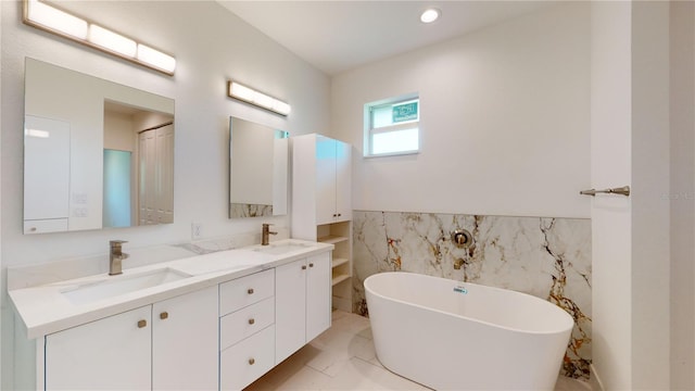 bathroom featuring a bathing tub, vanity, and tile walls