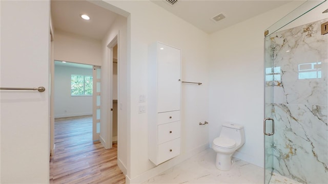 bathroom featuring toilet and a shower with shower door