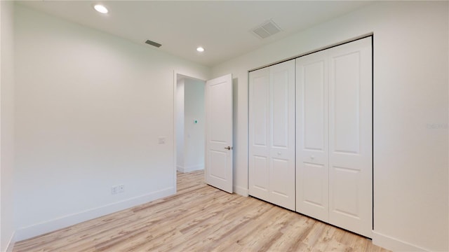 unfurnished bedroom featuring light hardwood / wood-style flooring and a closet