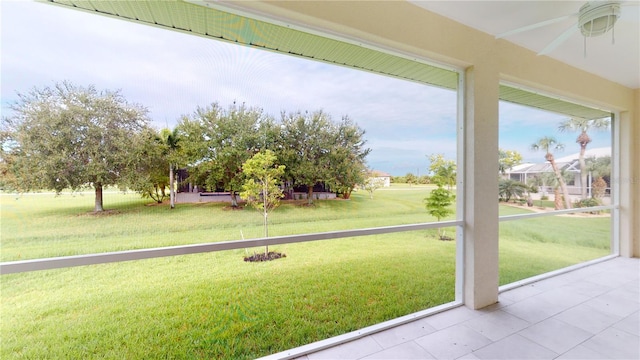 unfurnished sunroom featuring ceiling fan and a healthy amount of sunlight