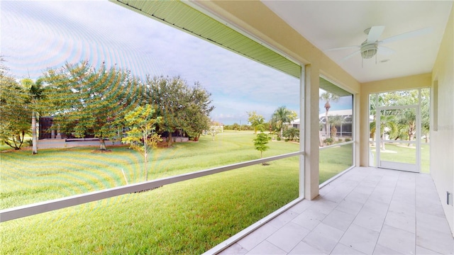 unfurnished sunroom with ceiling fan