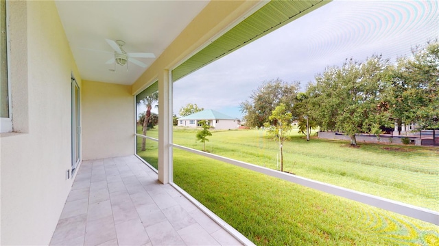 unfurnished sunroom with ceiling fan