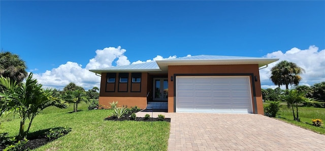 view of front of house featuring a front lawn and a garage