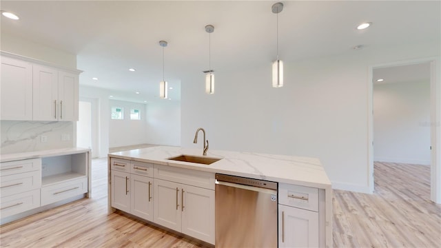 kitchen with light hardwood / wood-style floors, a center island with sink, white cabinets, dishwasher, and sink