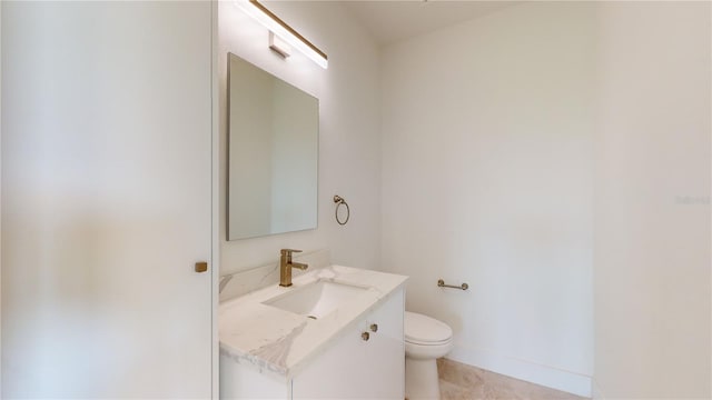 bathroom with toilet, tile flooring, and vanity