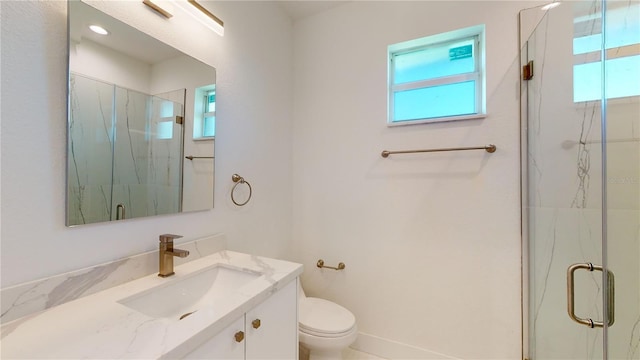 bathroom featuring toilet, a shower with door, and vanity