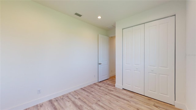 unfurnished bedroom with light hardwood / wood-style floors and a closet