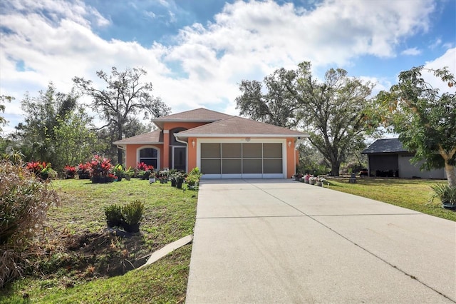 view of front of home with a front yard and a garage