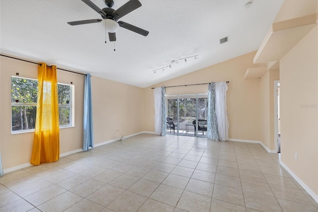 spare room featuring ceiling fan, track lighting, light tile floors, a textured ceiling, and vaulted ceiling